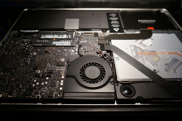 here we can see the exposed motherboard, fan, and battery in our example Macbook